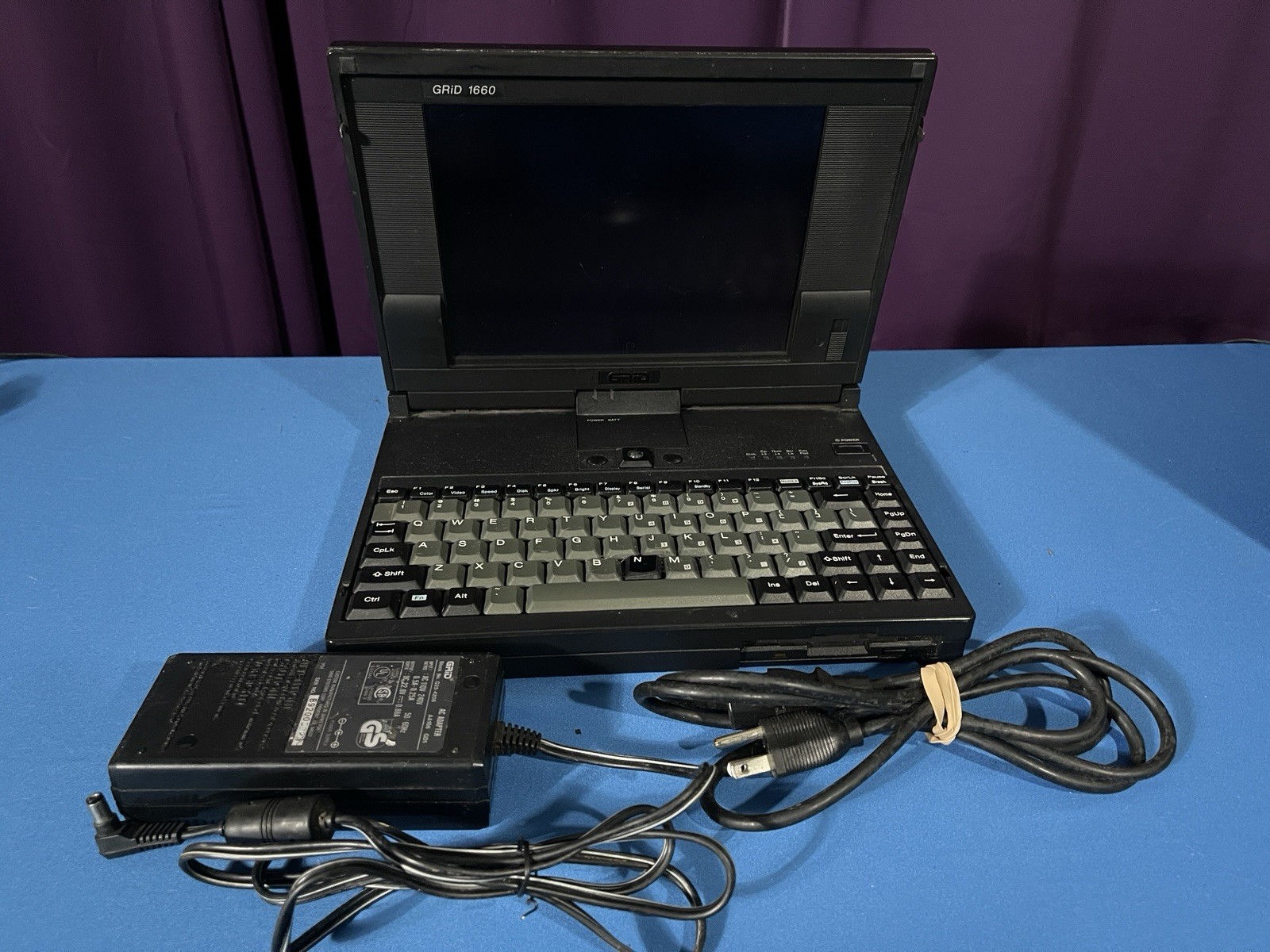 Grid 1660 Laptop & power cord- Powers On  WATCH VIDEO needs new hdd & battery